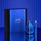 Blue Rhapsody perfume set by SJP Parfum Collection, featuring a large blue and black box, a ribbed blue bottle, and a matching blue travel spray vial with a gold cap, set against a blue striped background.